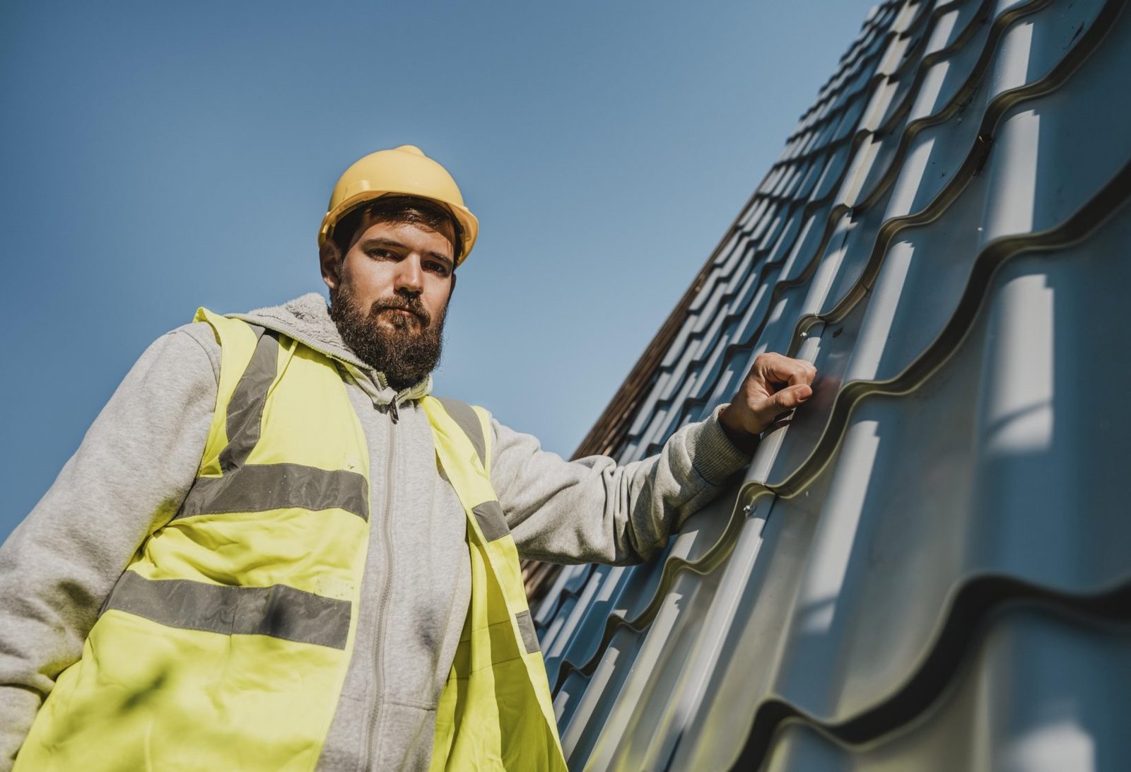 low-view-man-working-roof-with-drill